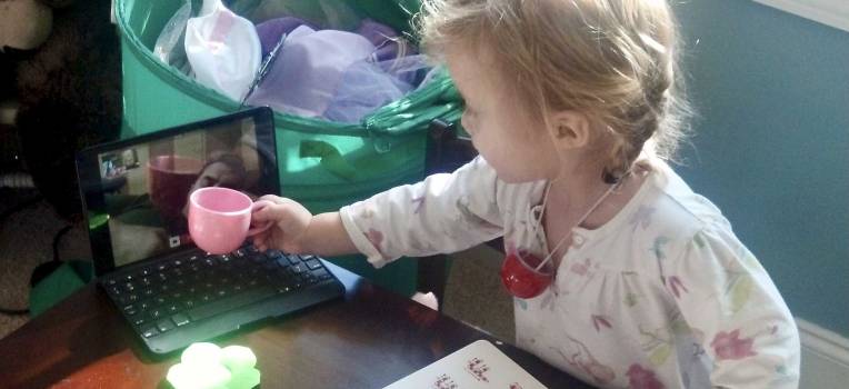 Russell Worth Parker with then-three-year-old daughter having a Christmas tea party with her dad by Skype while he was deployed.